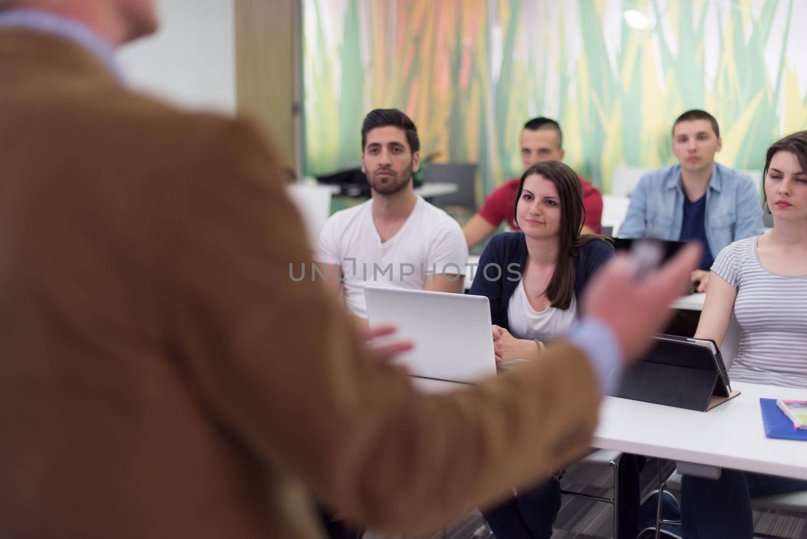 teacher with a group of students in classroom by dotshock