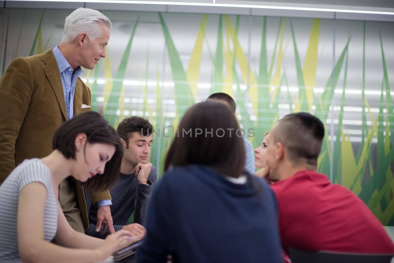 teacher with a group of students in classroom by dotshock