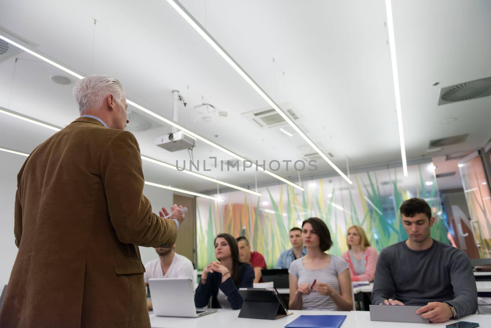 group of students study with professor in modern school classroom