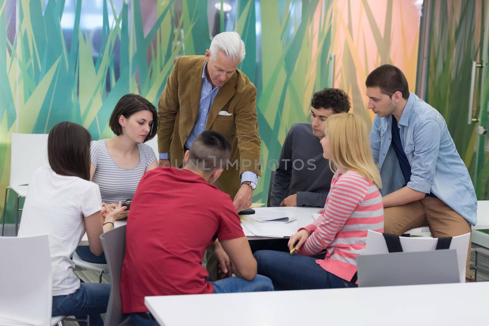 group of students study with professor in modern school classroom