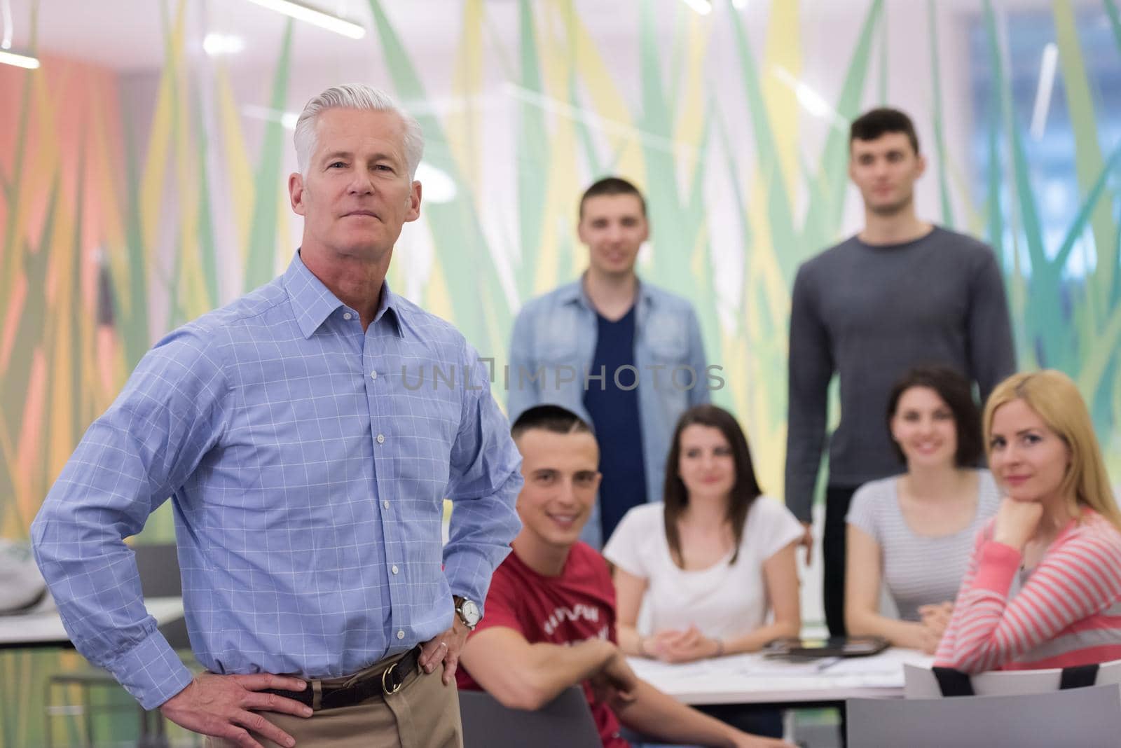 portrait of confident teacher,  students group in background