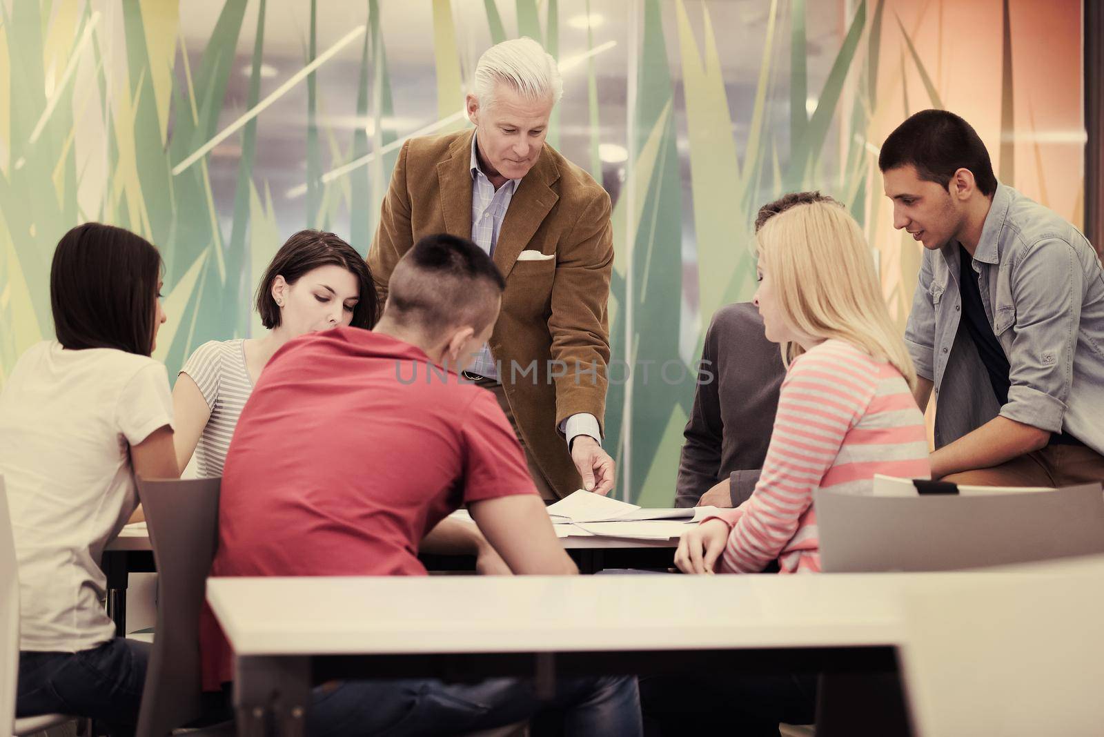 group of students study with professor in modern school classroom