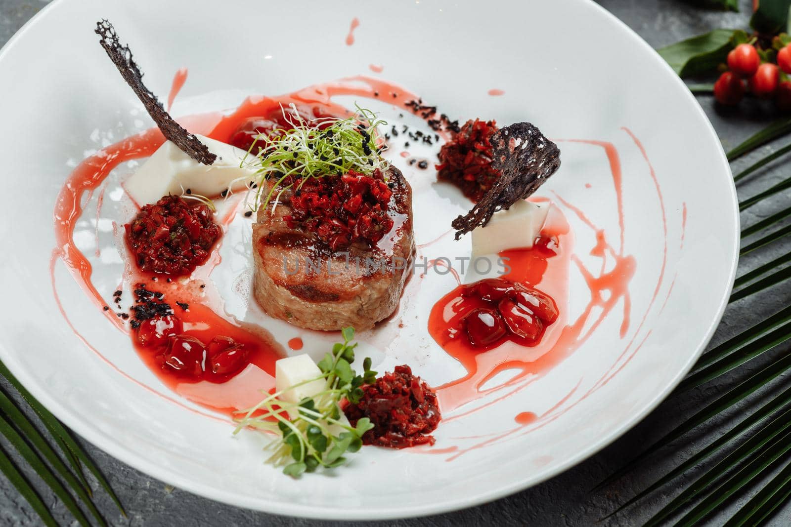 Appetizing beef in sweet sauce close up. Chopped beef meat in cherry sauce with vegetables on plate. Delicious european cuisine by UcheaD