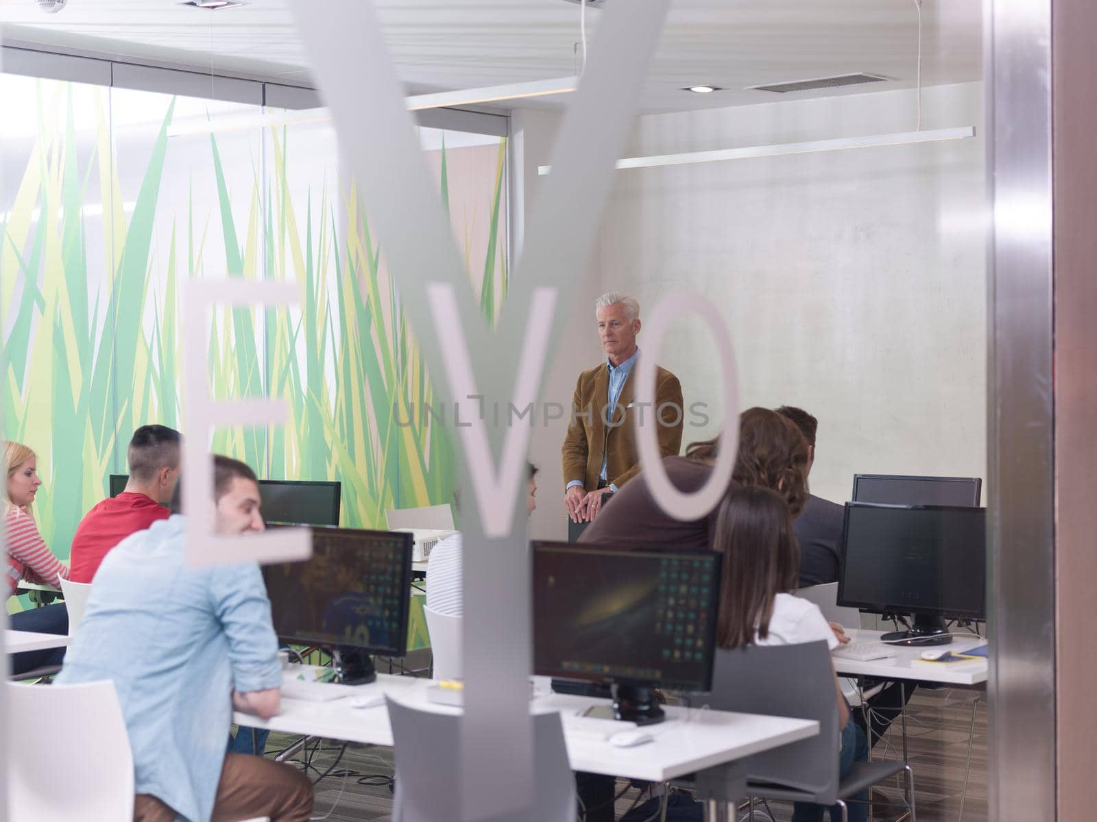 senior teacher and students group in computer lab classroom by dotshock