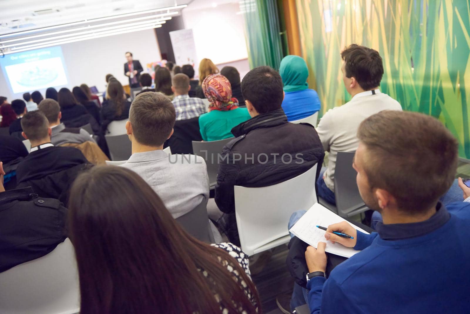 young business people taking notes on education training conference seminar, students at modern classroom