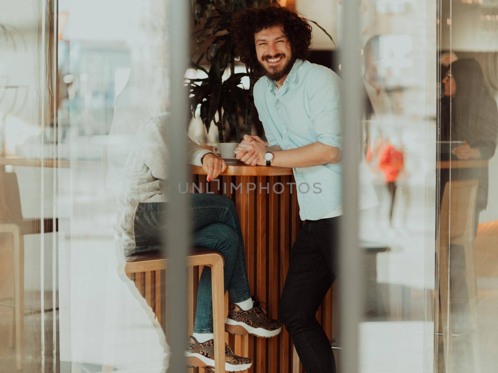 A happy business couple is drinking coffee and smiling while sitting at the cafe