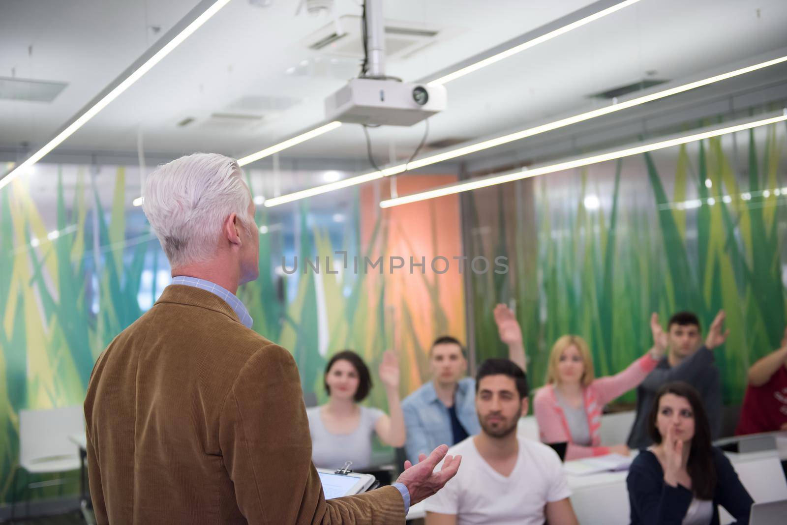 group of students study with professor in modern school classroom