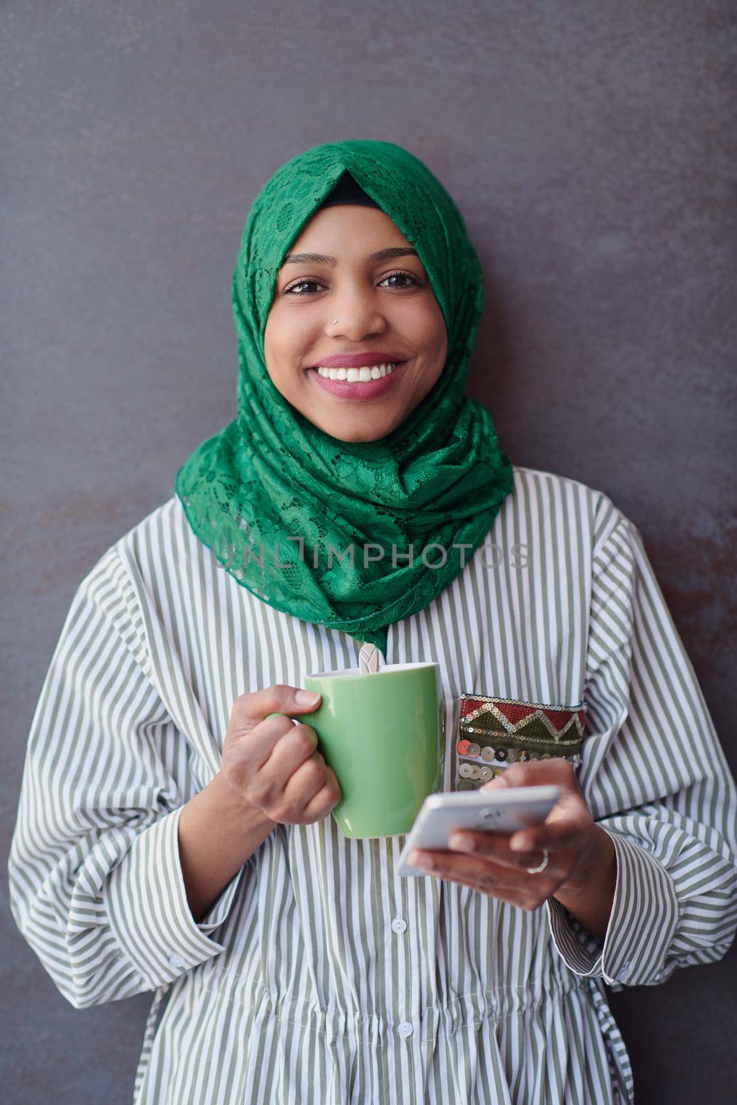 african muslim businesswoman with green hijab using mobile phone by dotshock