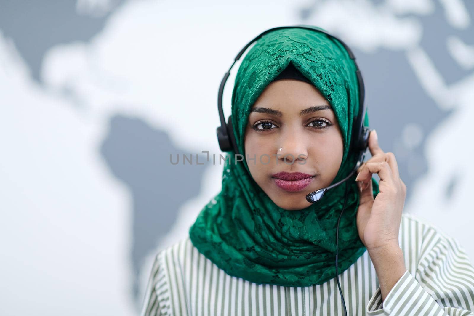 African muslim female with green hijab scarf customer representative business woman with phone headset helping and supporting online with customer in modern call centre