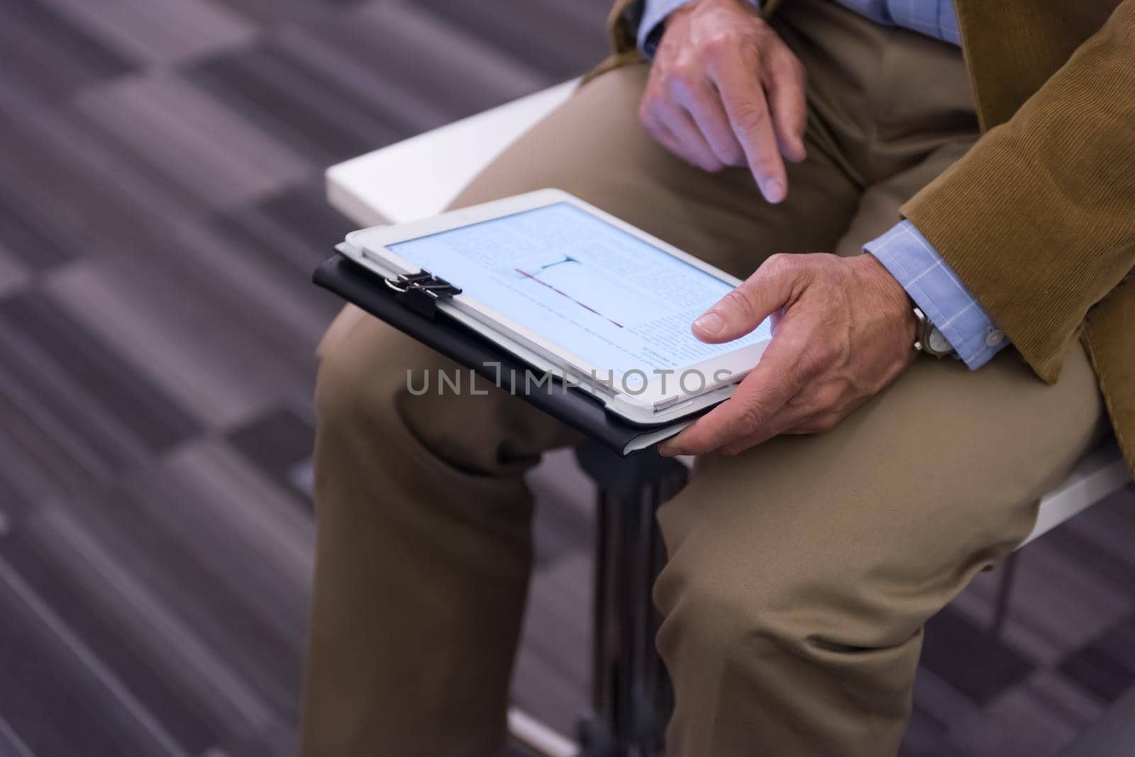 Closeup of mature hands holding tablet. by dotshock
