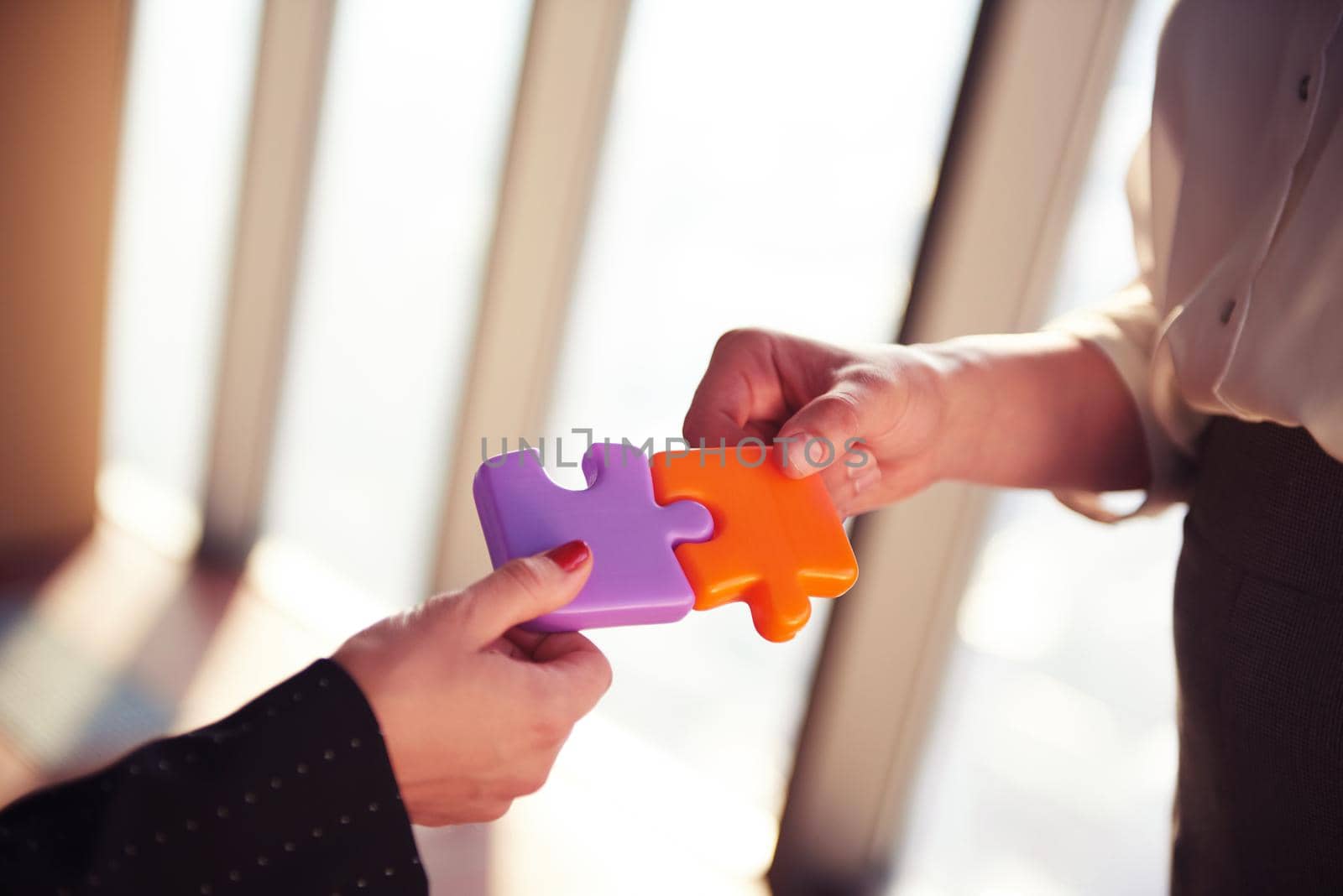 business people group assembling jigsaw puzzle and represent team support and help concept, top view perspective at modern bright office interior