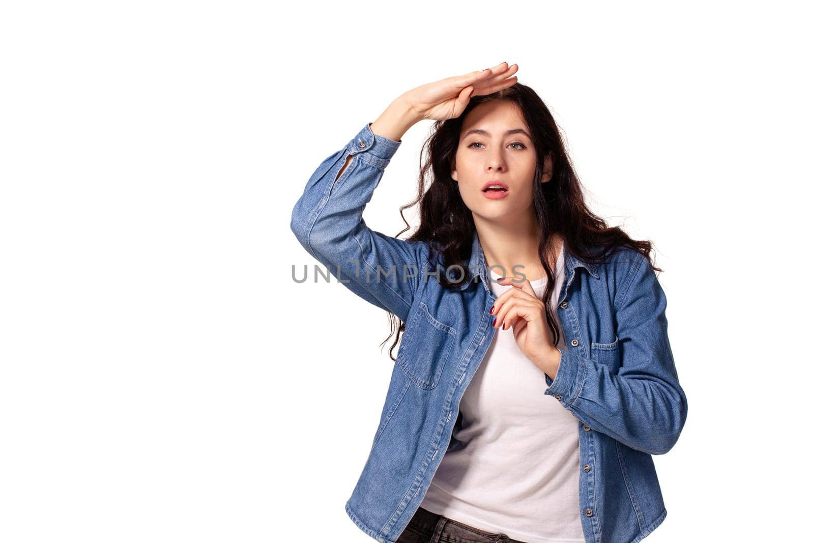 Serious woman looking forward and having put her palm to foreheadon white background