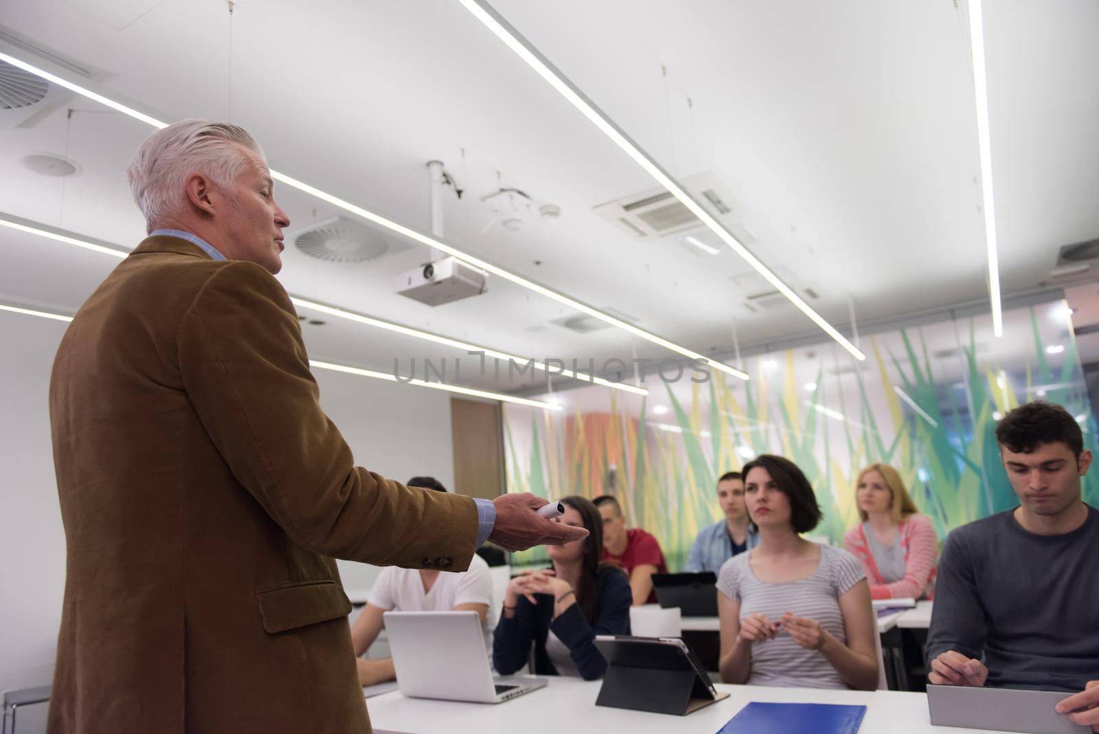 group of students study with professor in modern school classroom