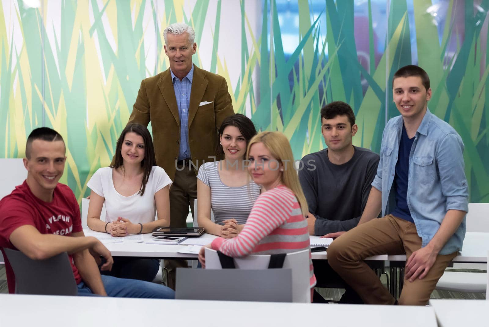 portrait of confident teacher,  students group in background