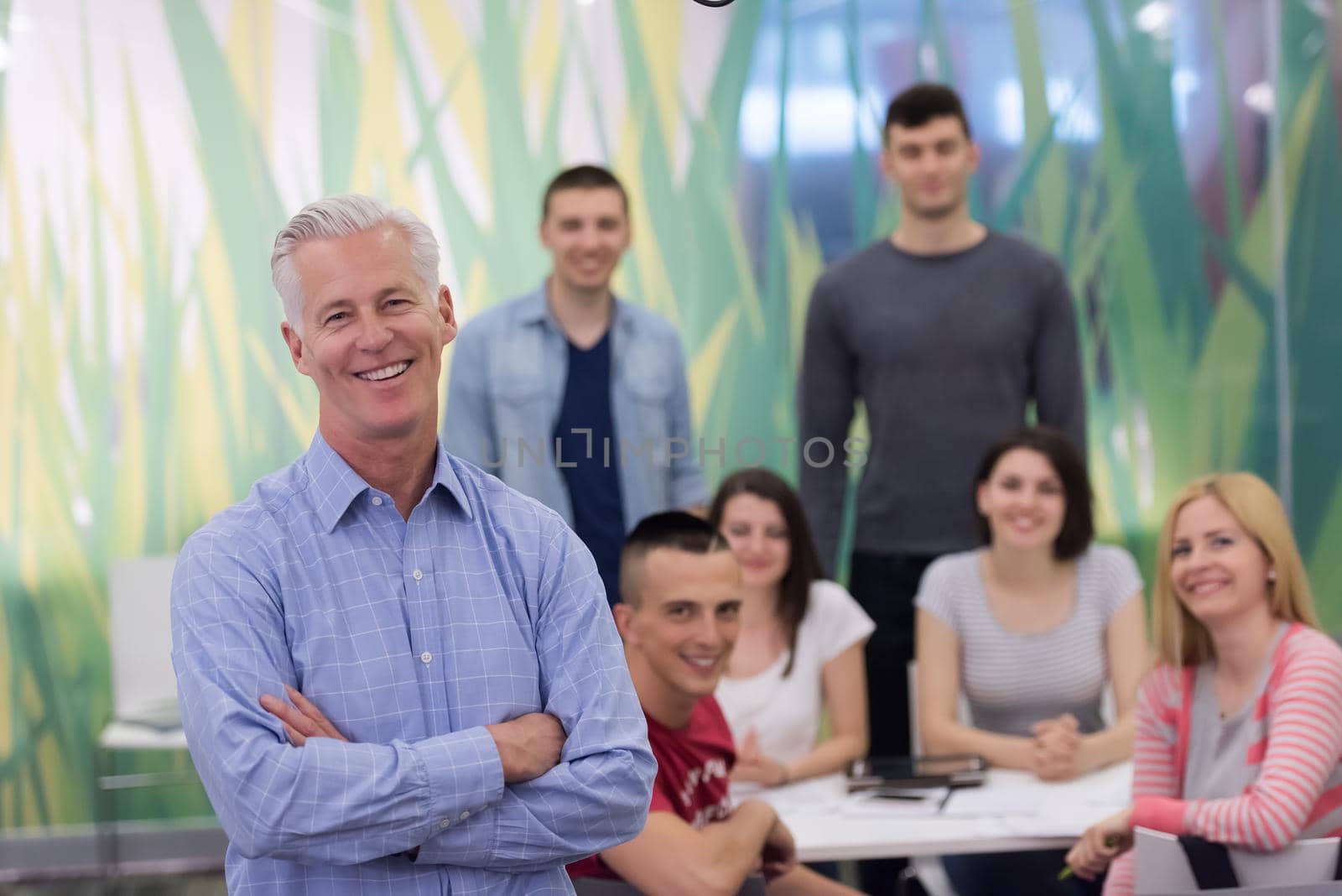 portrait of confident teacher,  students group in background