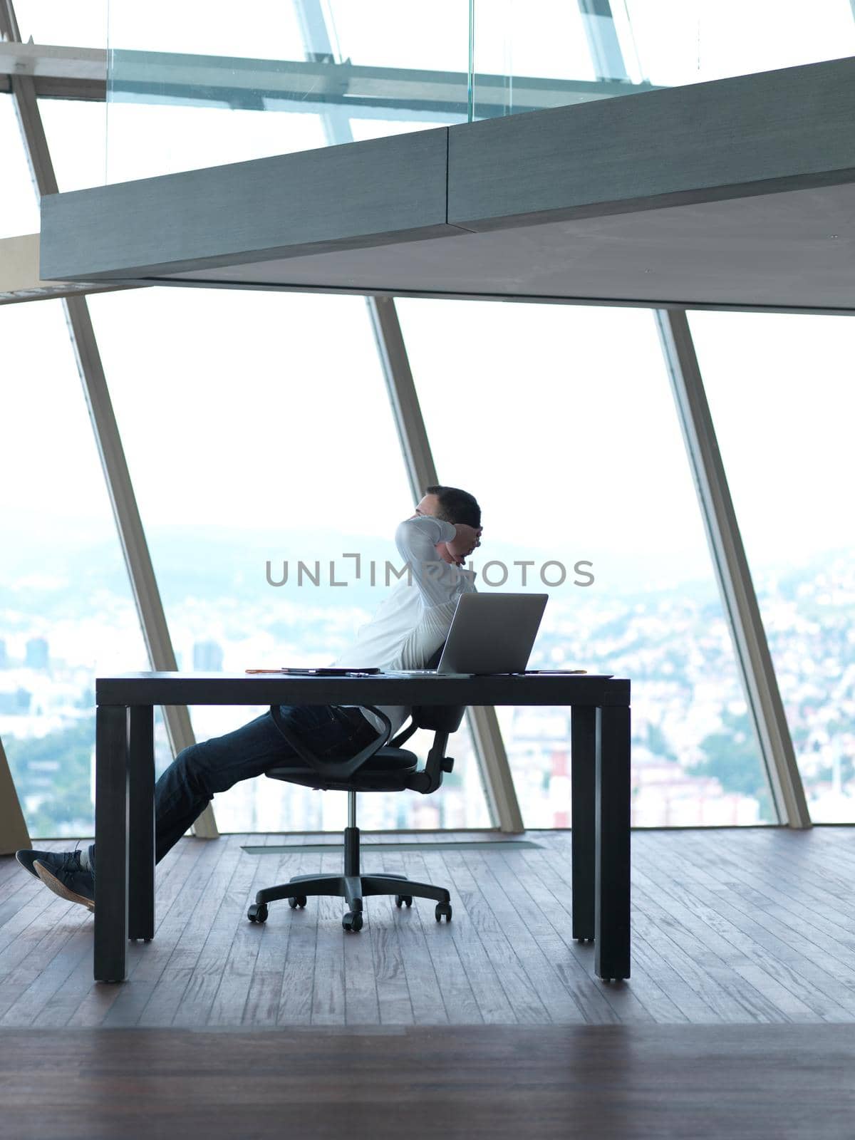 happy young business man work and relax at modern bright office interior, hipster with beard at workplace