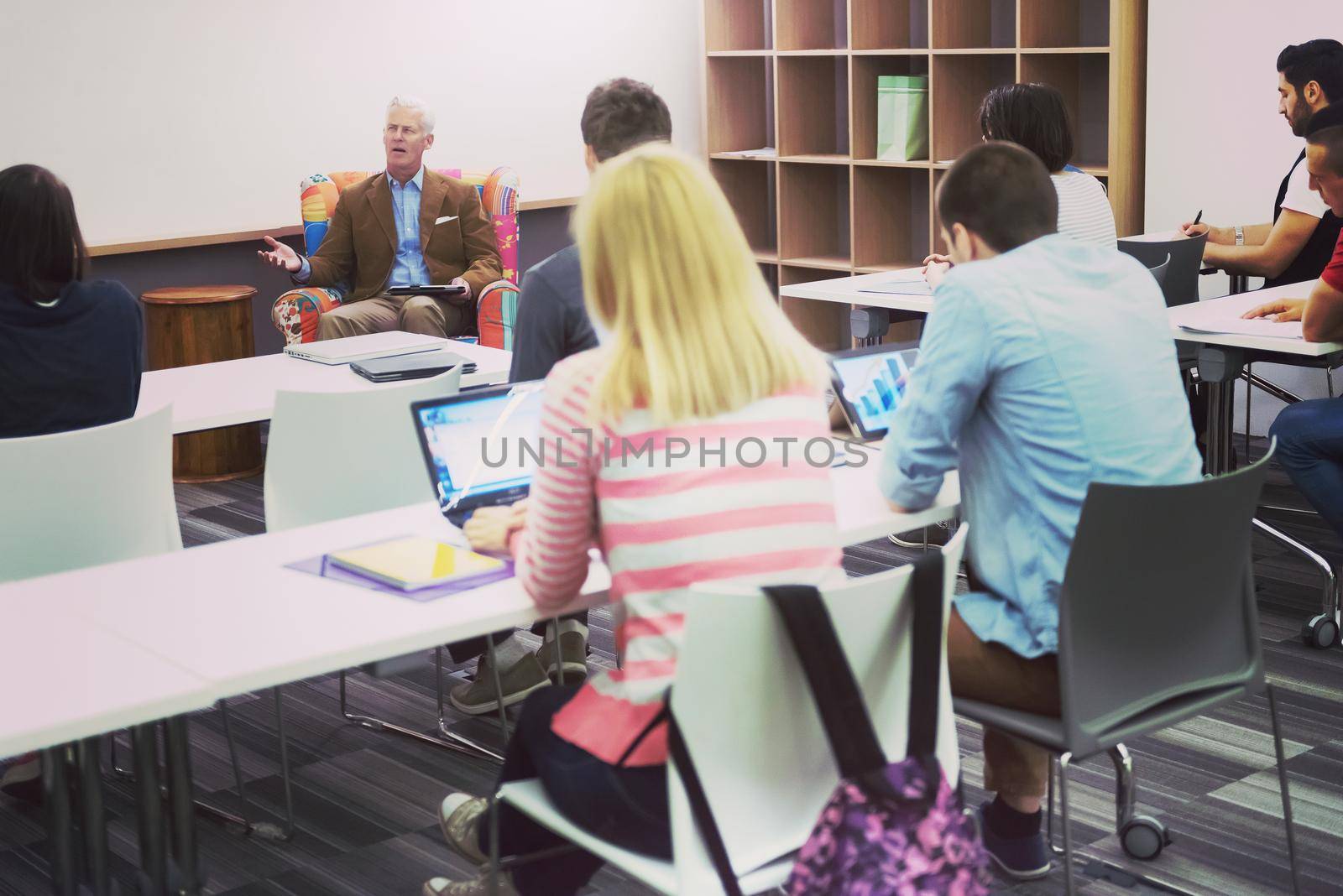 group of students study with professor in modern school classroom