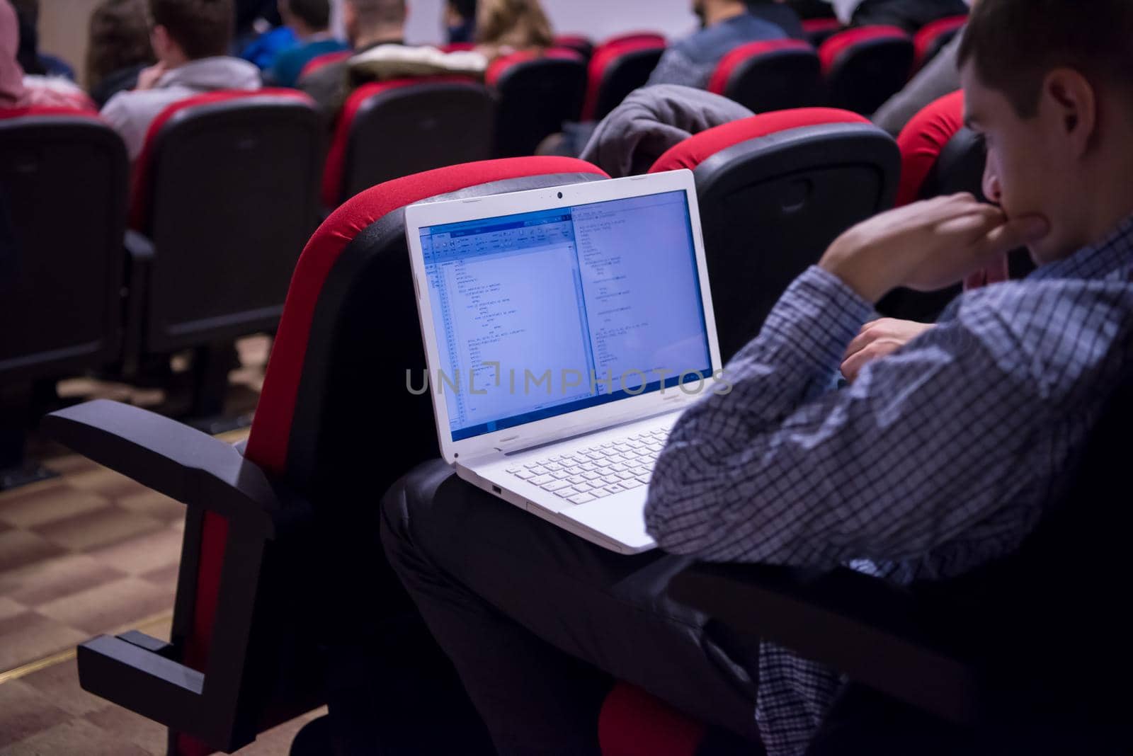 businessman using laptop computer during seminar by dotshock