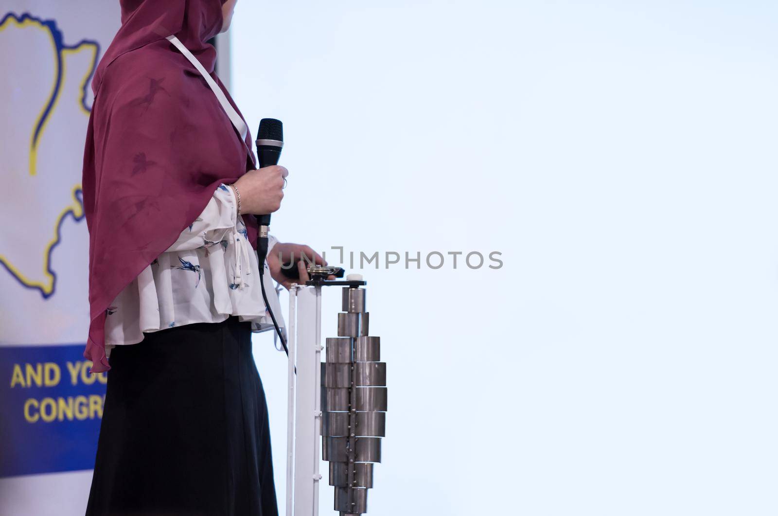 young muslim businesswoman with red scarf at business conference room giving public presentations. Audience at the conference hall. Entrepreneurship club