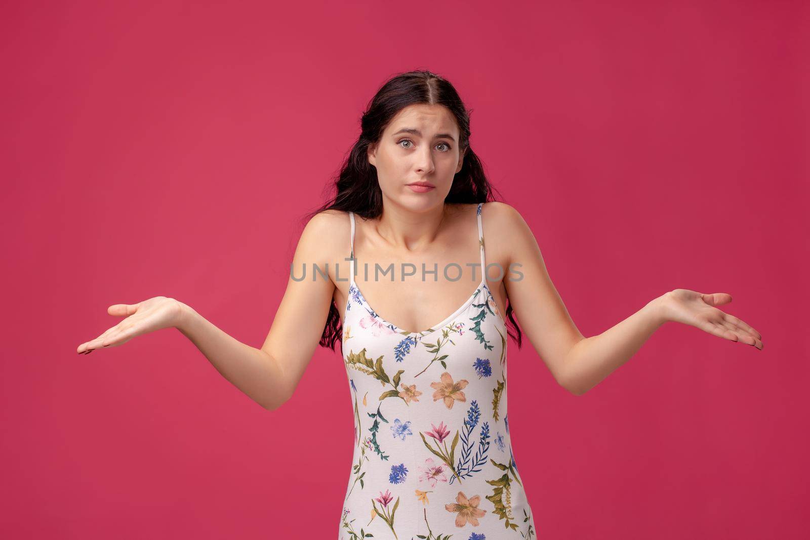 Beautiful, sweet, young girl spreads her arms on the pink background
