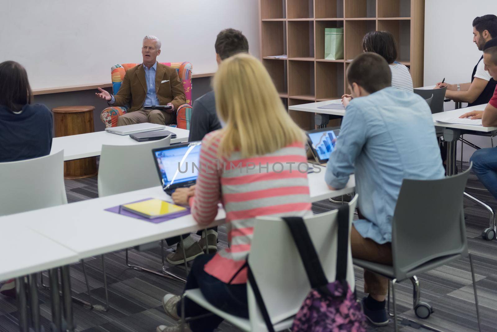 group of students study with professor in modern school classroom