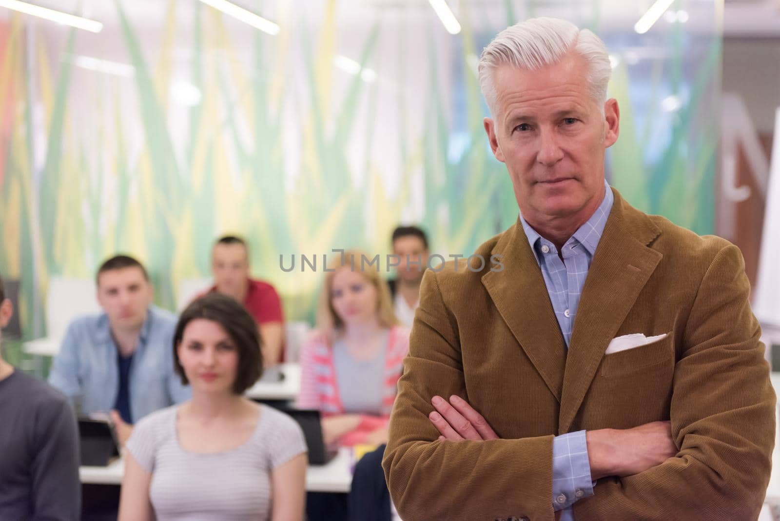 portrait of confident teacher,  students group in background