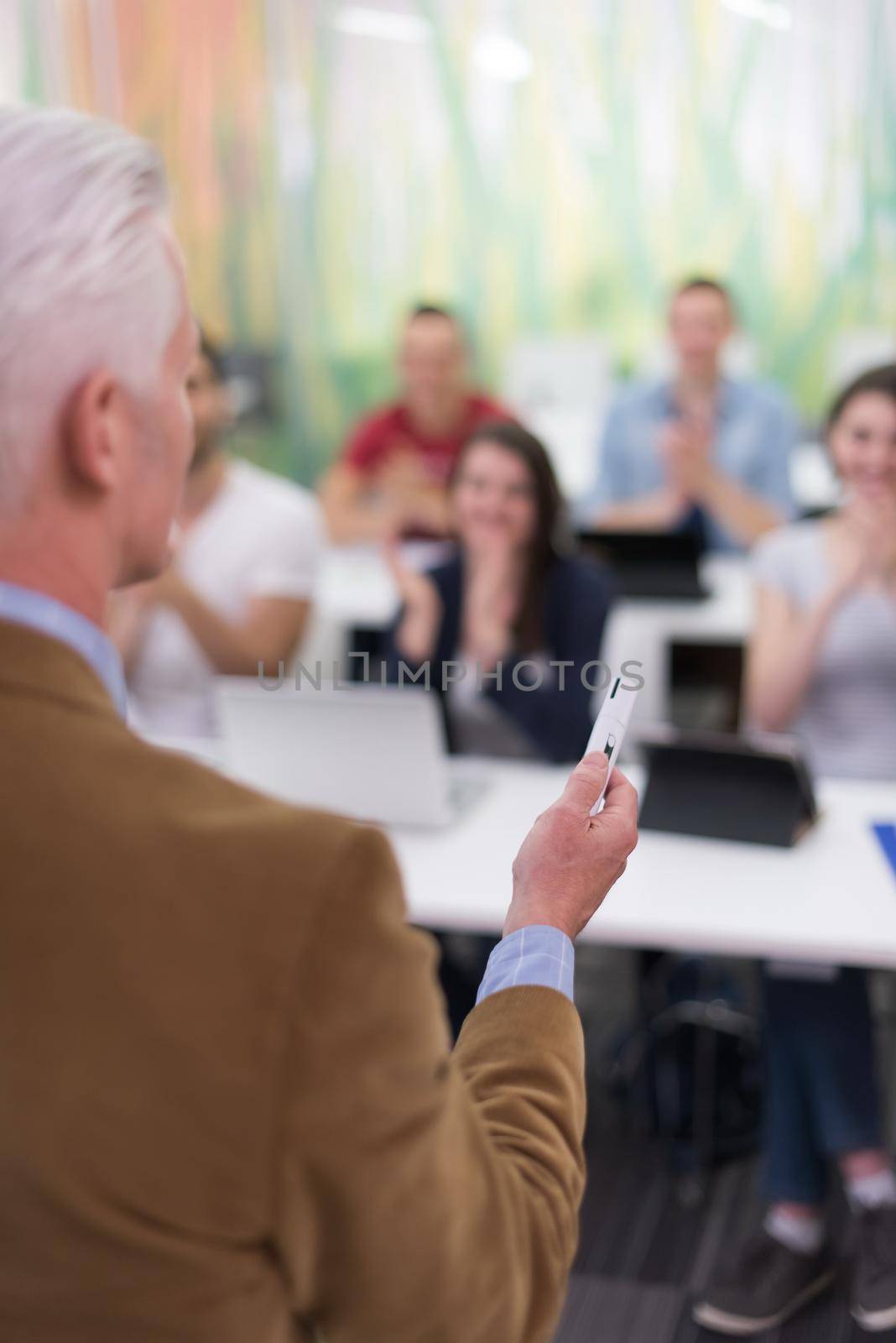 teacher with a group of students in classroom by dotshock