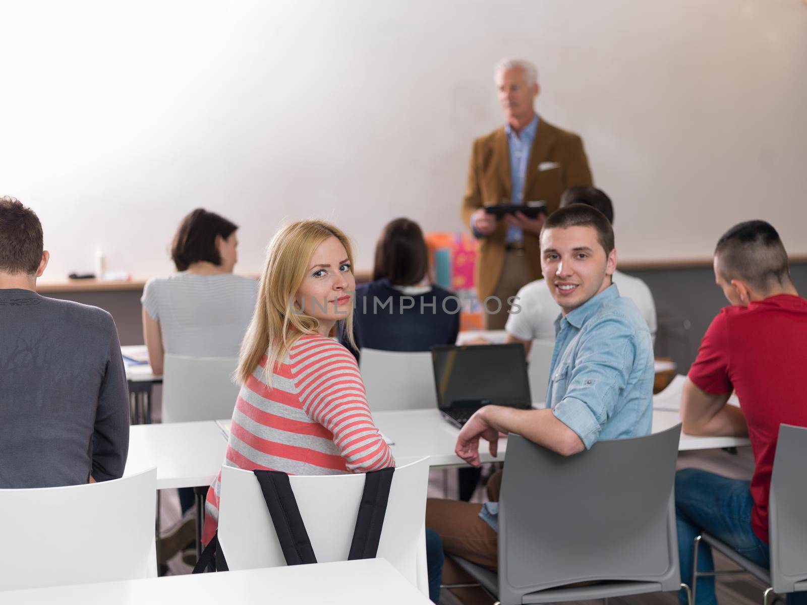 teacher with a group of students in classroom by dotshock