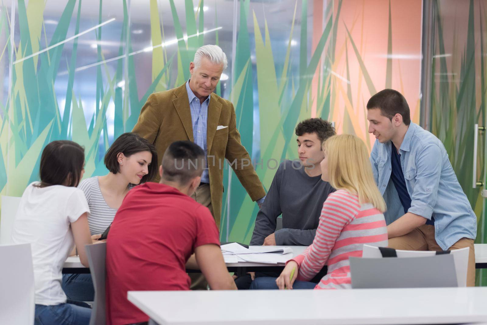 teacher with a group of students in classroom by dotshock