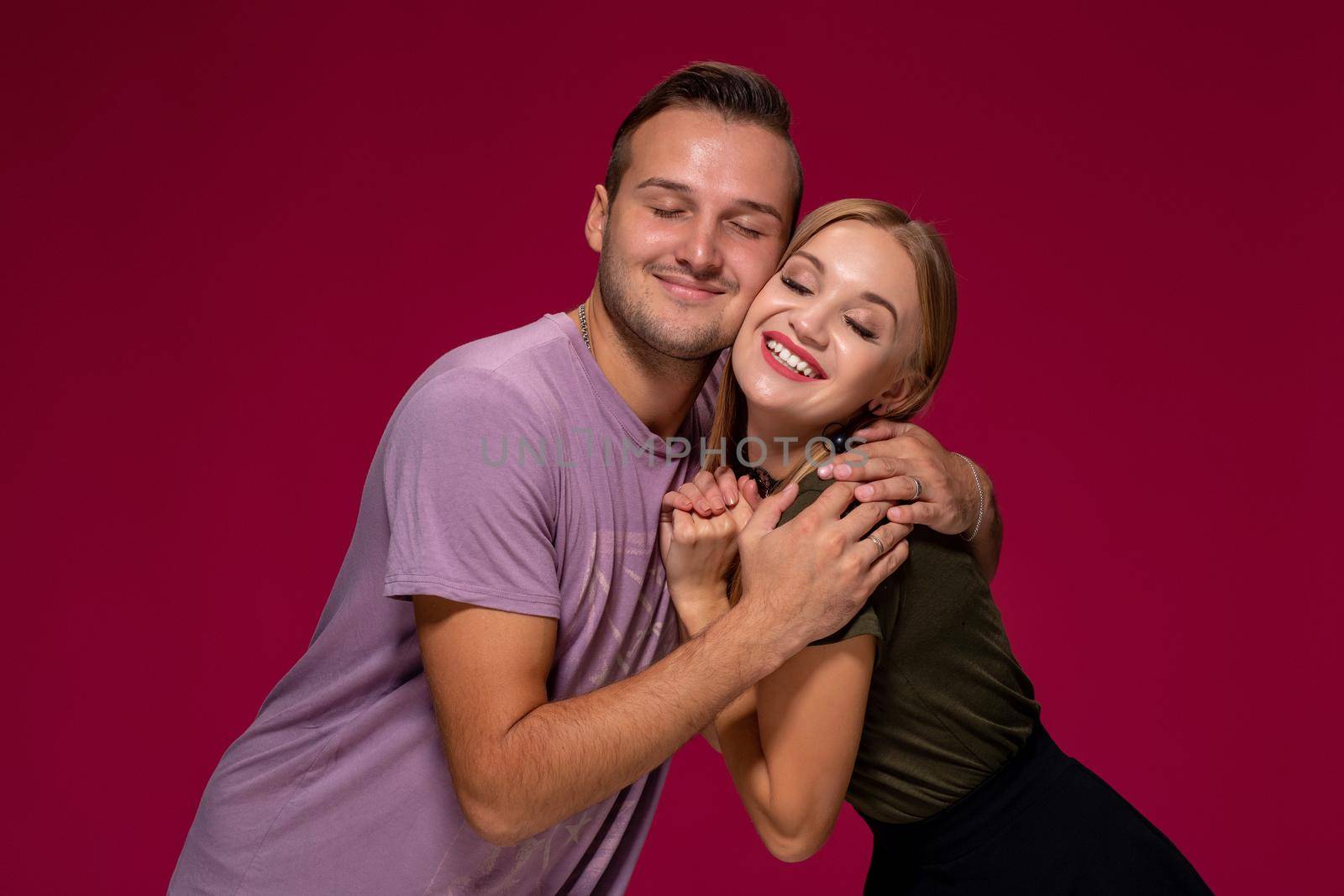 Girlfriend decided with her cute boyfriend to buy puppy. Indoor studio shot on burgundy background. by nazarovsergey