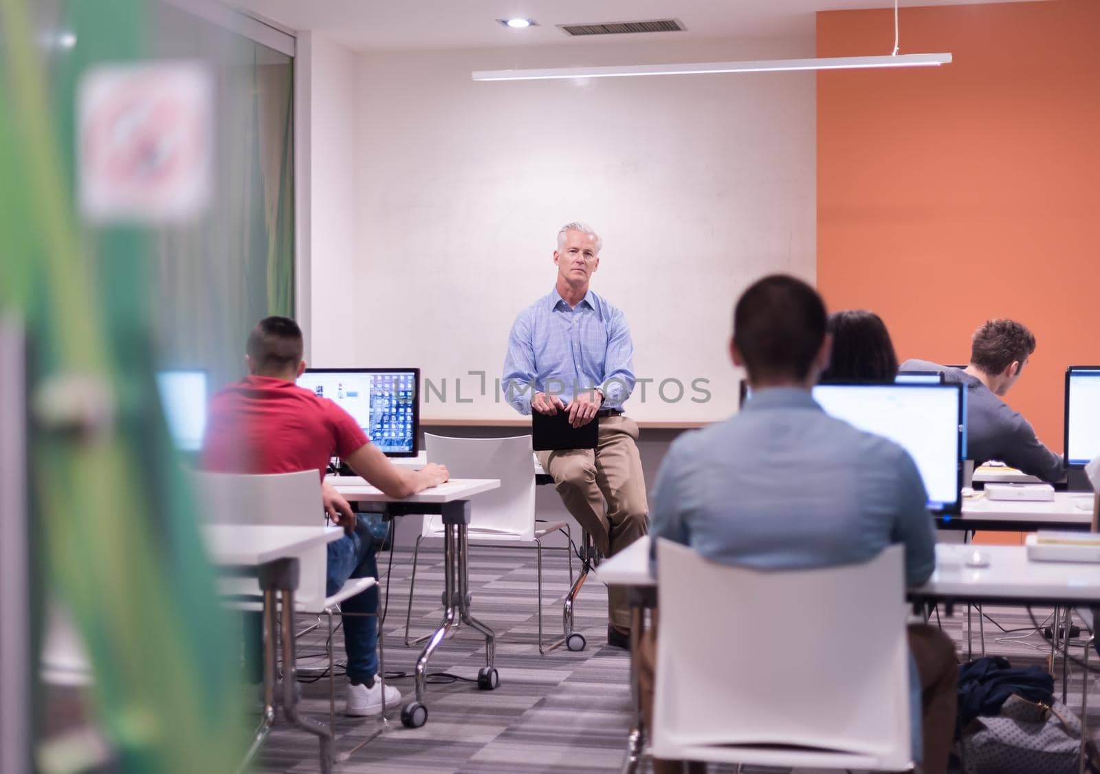 teacher and students in computer lab classroom by dotshock