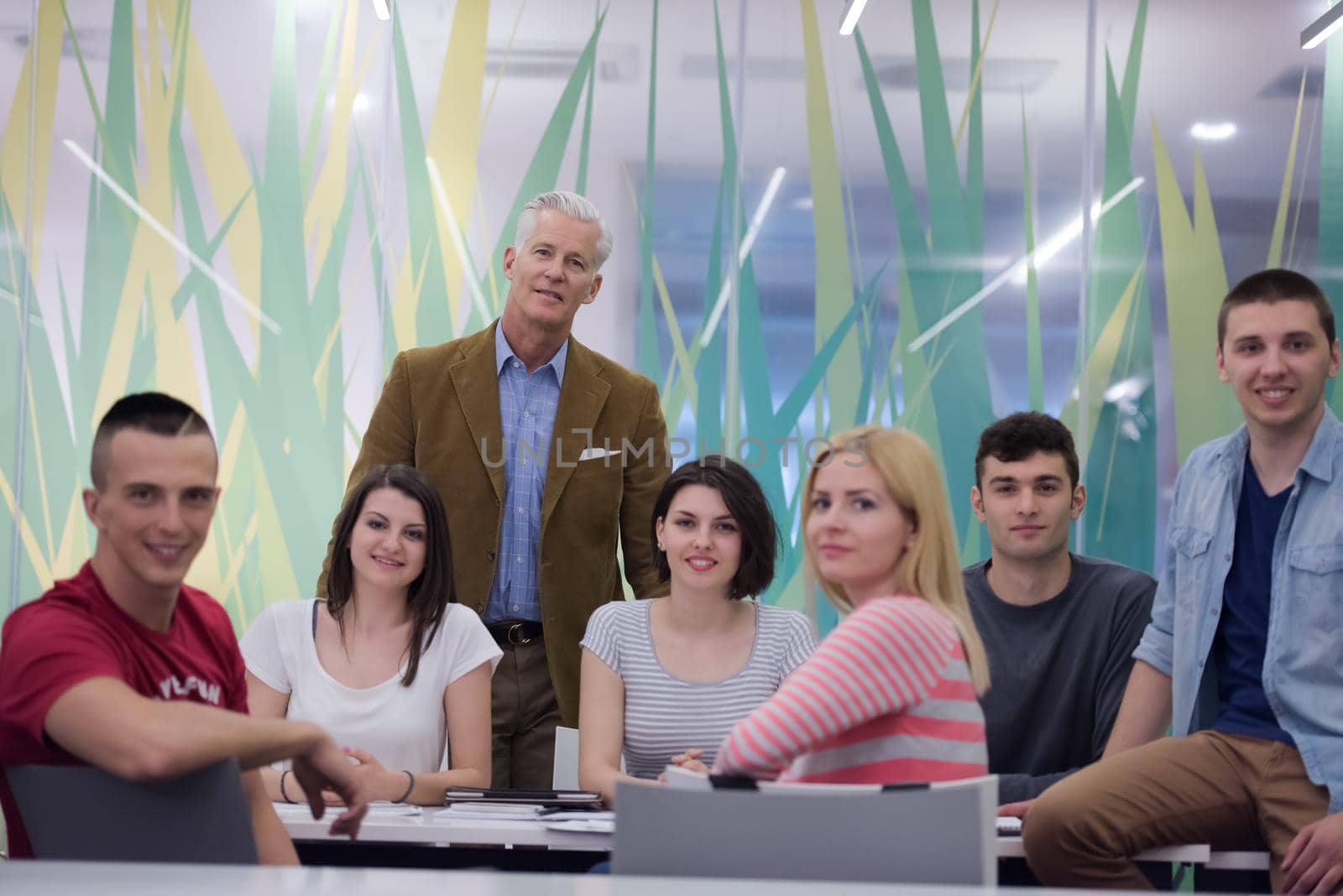 portrait of confident teacher,  students group in background