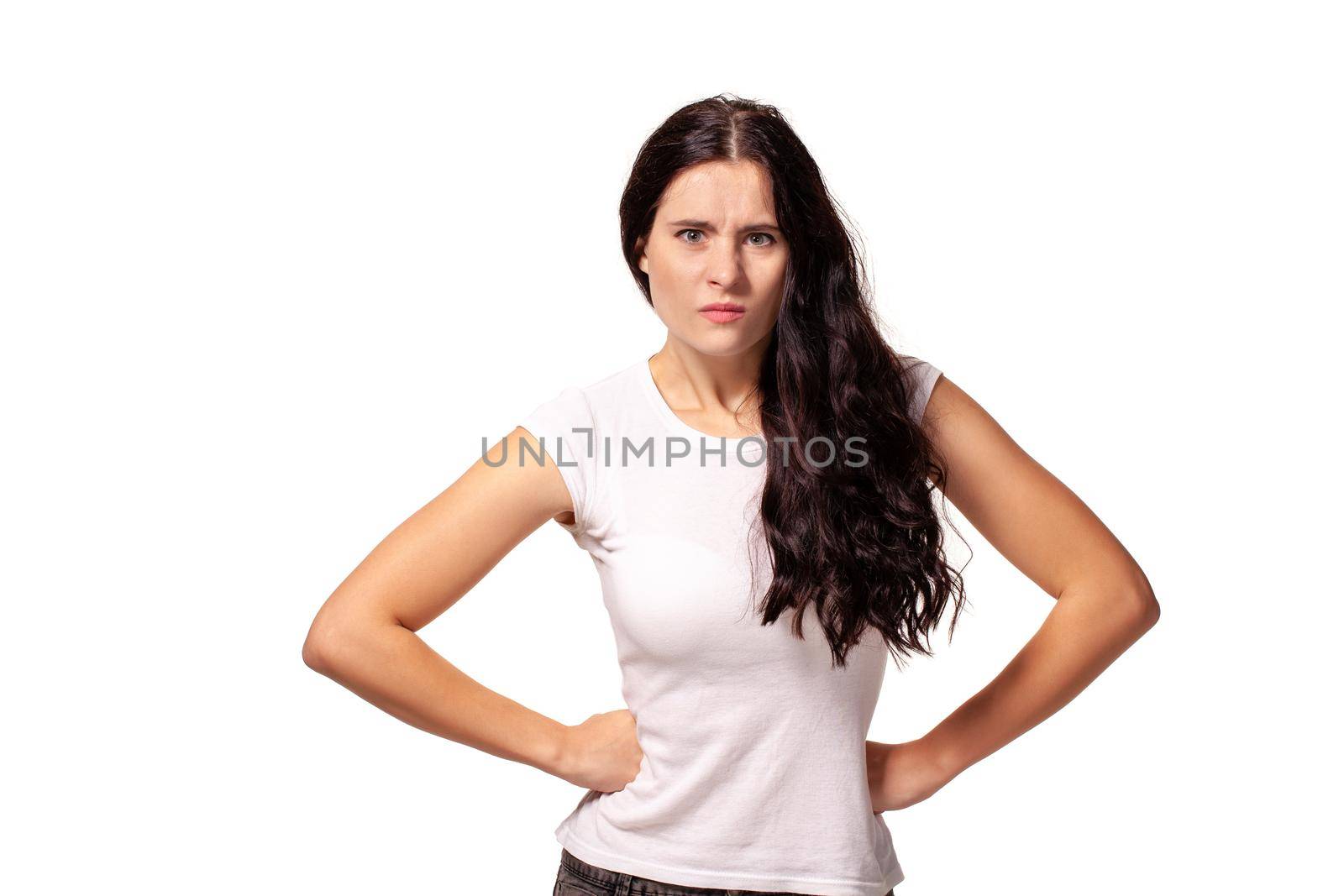 Angry girl standing with hands on waist and looking at camera isolated on white