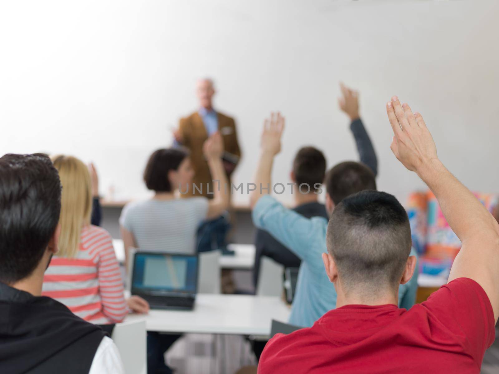 students group raise hands up on class by dotshock