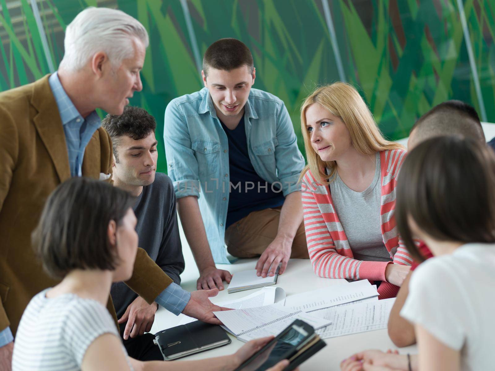 group of students study with professor in modern school classroom