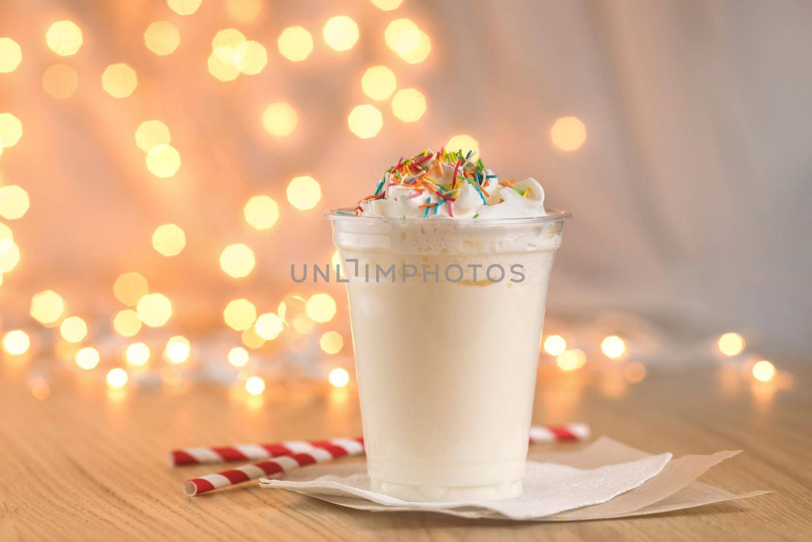 Jar of Christmas milk drink on wooden rustic table with winter holiday background. Milkshake on the background of the New Year's garland