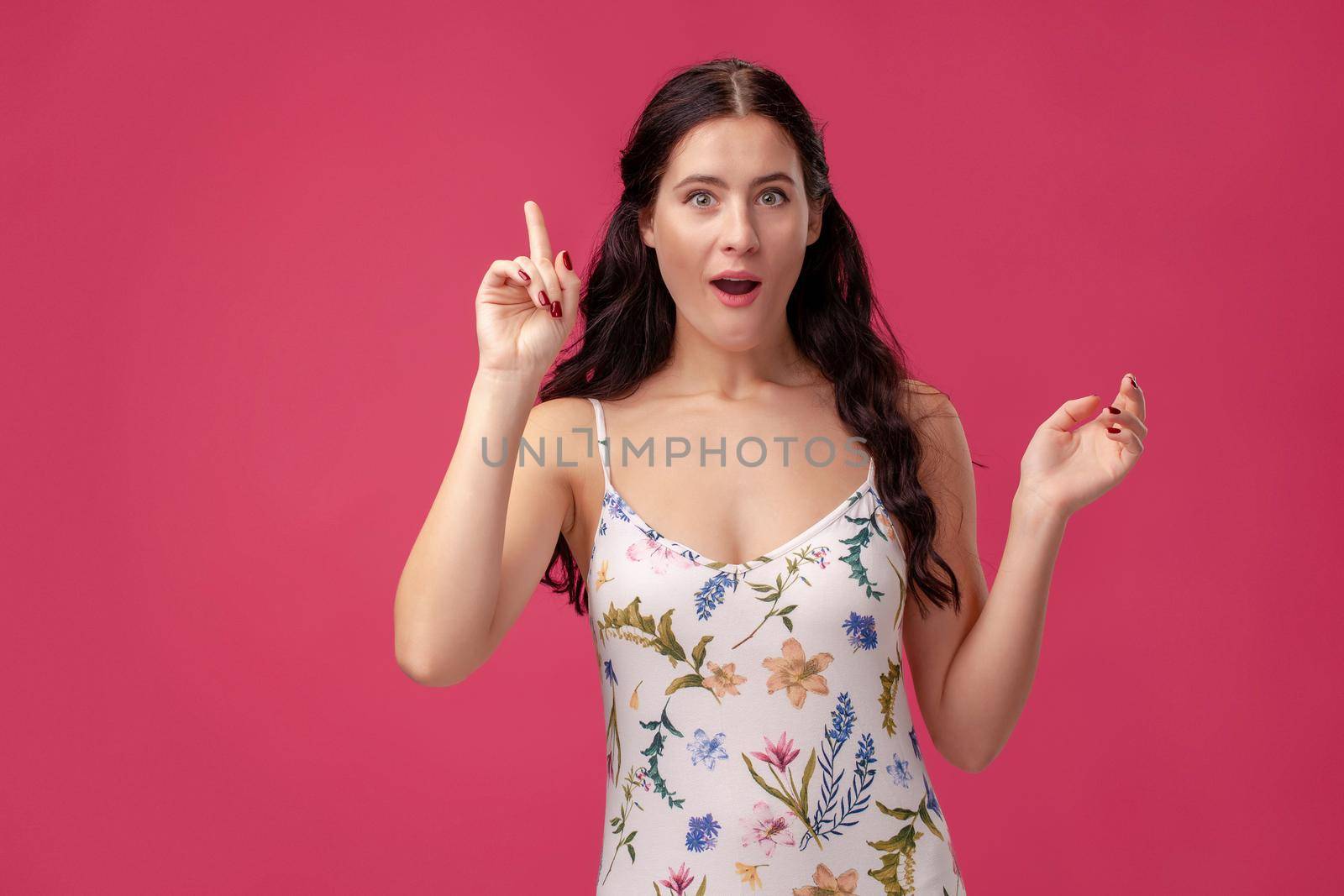 Smiling serious girl holding her index finger in front, saying: I have idea on the pink background