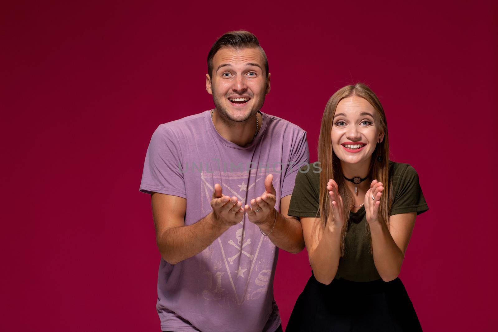 Girlfriend decided with her cute boyfriend to buy puppy. Indoor studio shot on burgundy background. by nazarovsergey