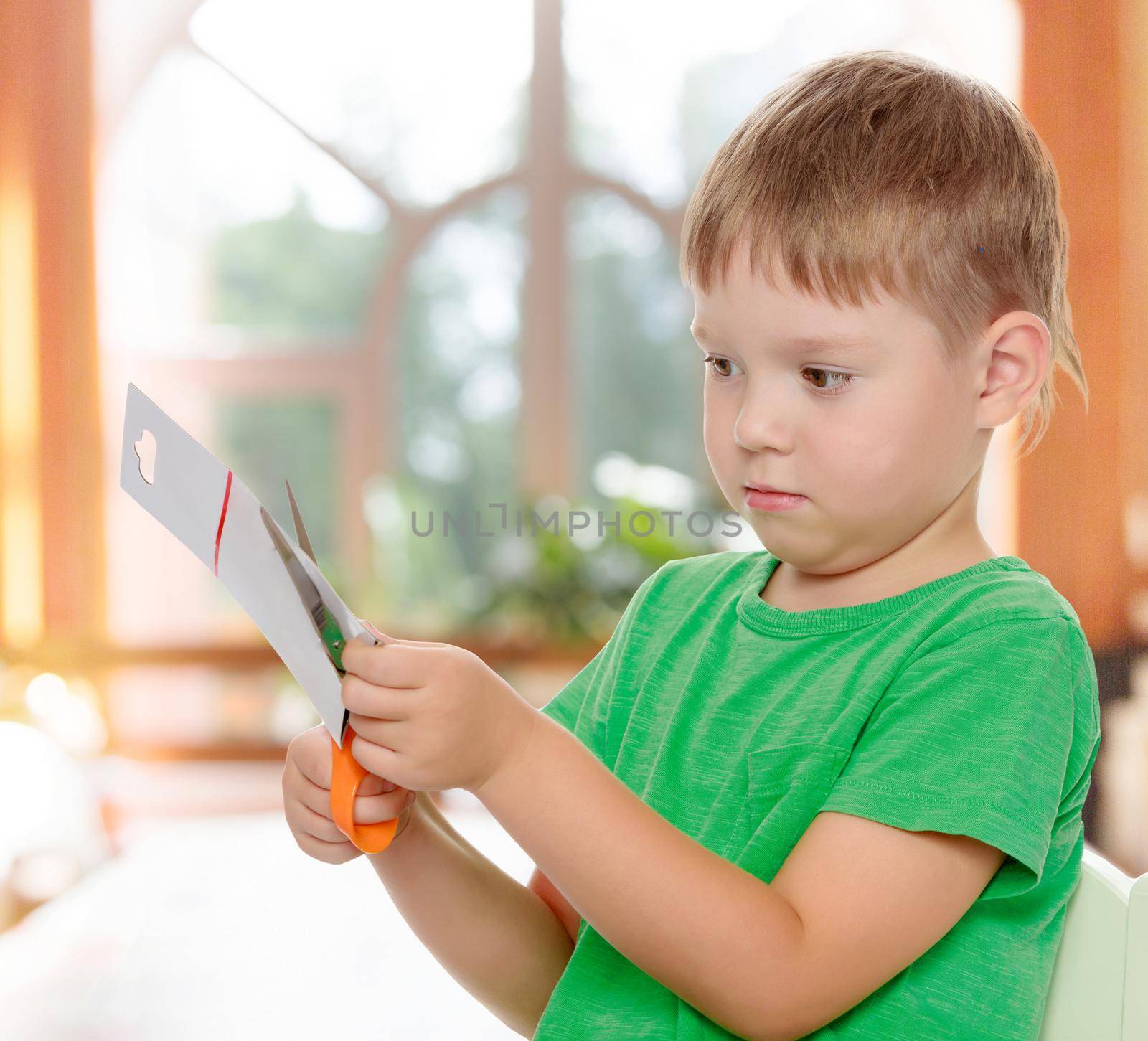 Boy cuts with scissors cardboard by kolesnikov_studio