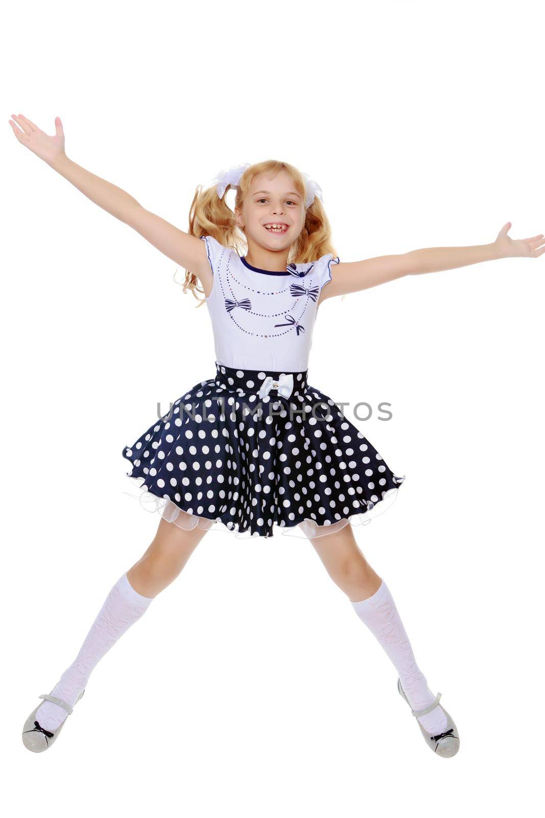 Happy little girl in the short polka-dot dress jumps , spread wide his arms and legs-Isolated on white background