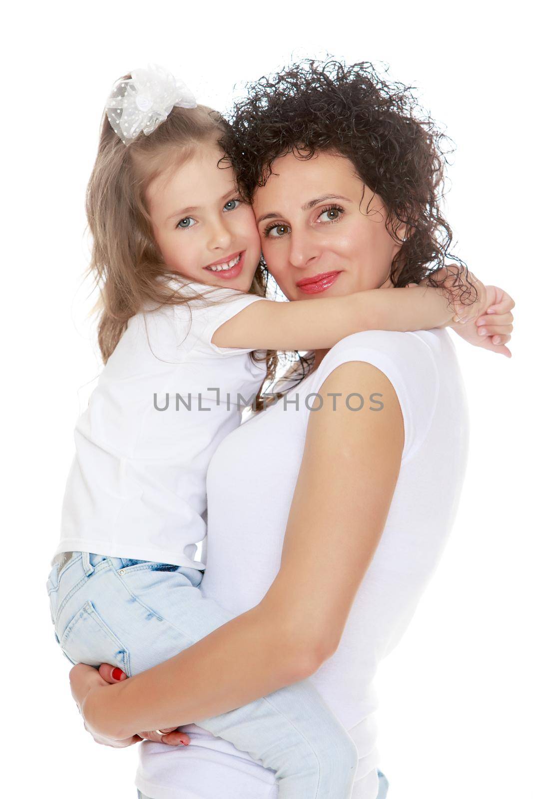 Happy, charming young mother with adorable little daughter. In the same jeans and white t-shirts without a pattern. Mother holds daughter on hands . close-up - Isolated on white background