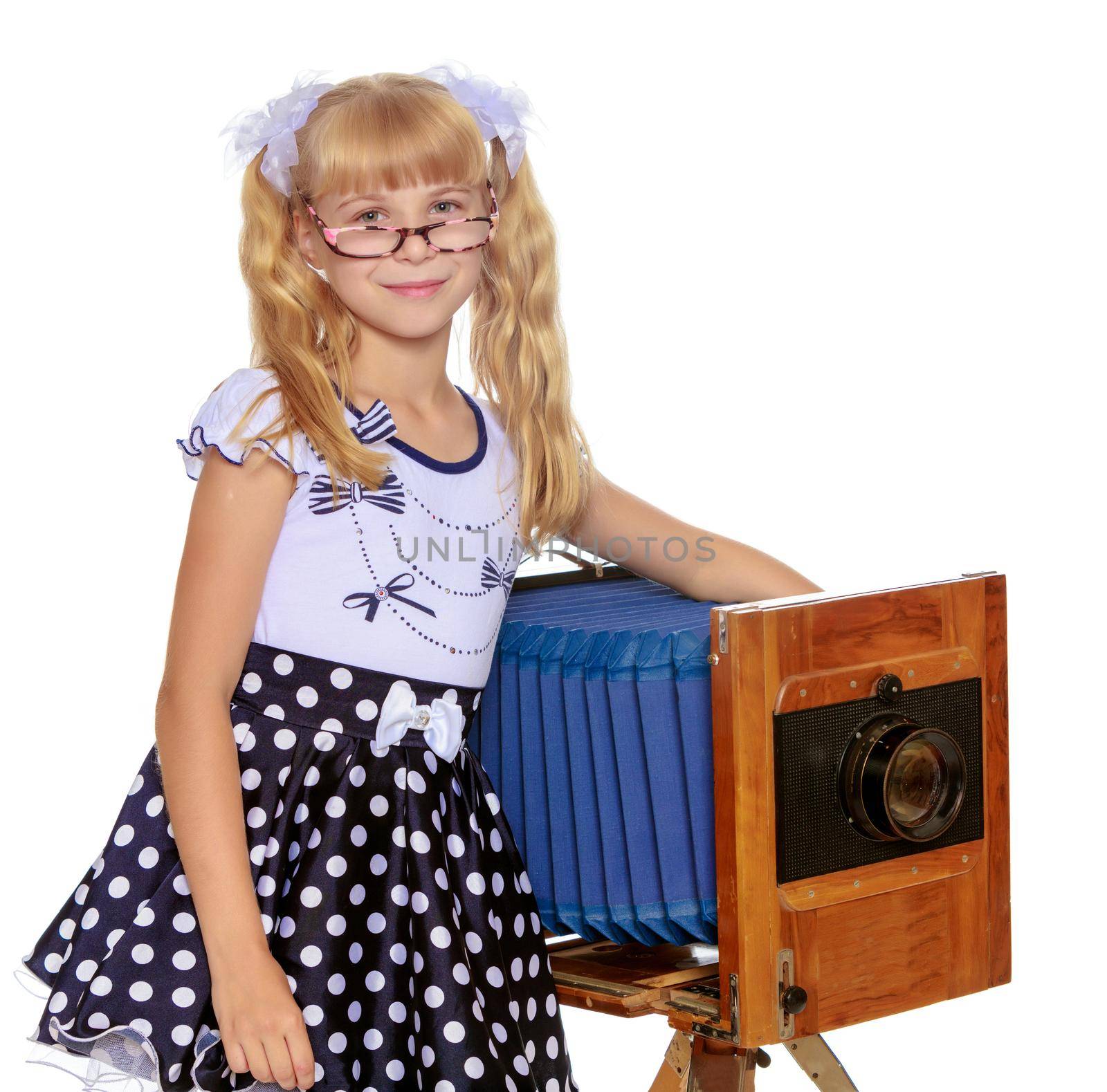 Beautiful little blonde girl near the large, wooden, vintage camera-Isolated on white background