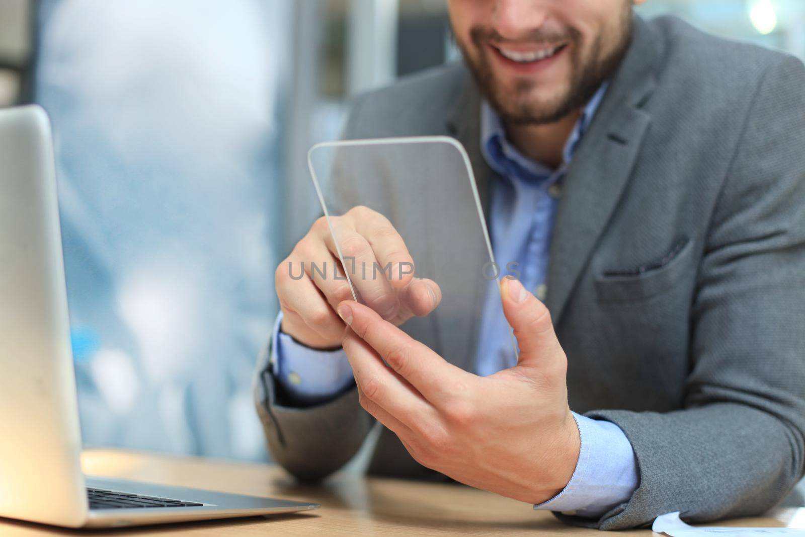 Future concept. Businessman holds futuristic transparent smart phone