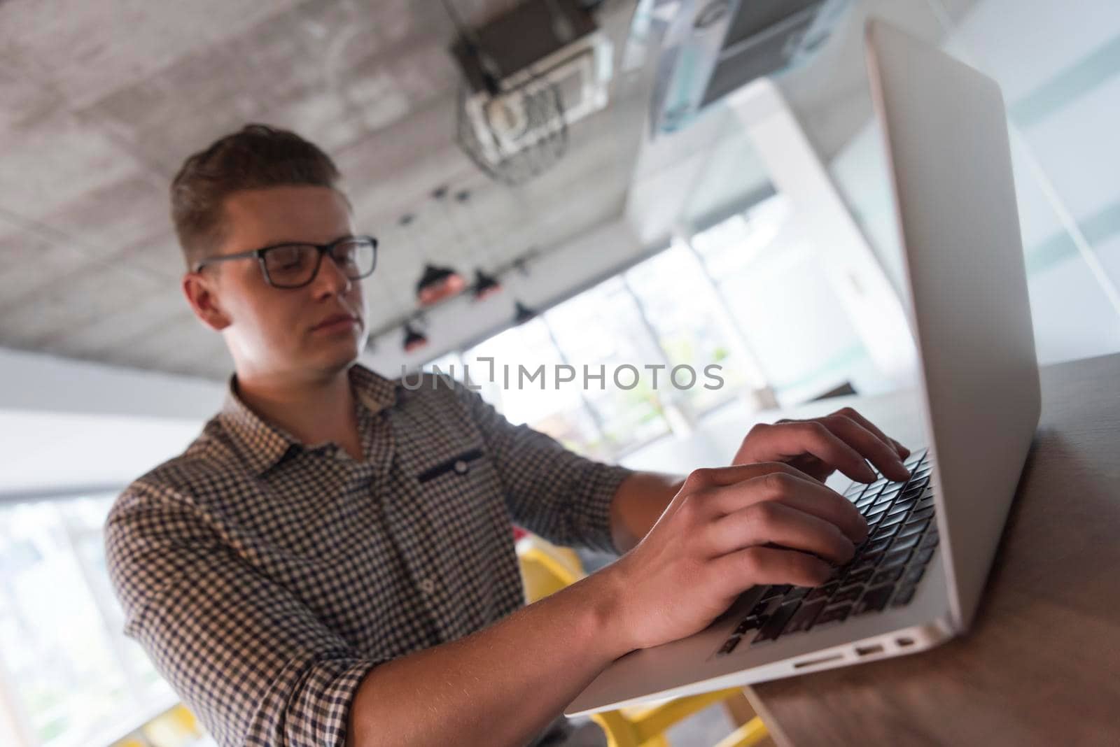 young businessman with glasses at  startup business office space working on modern  laptop  computer