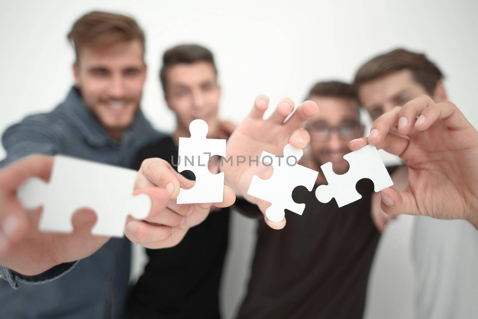 group of young people with puzzle pieces.the concept of solving the problem