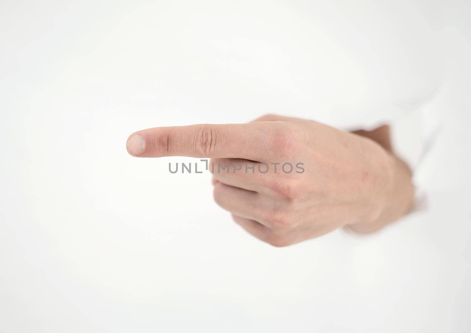 man's hand breaking through the paper wall and pointing at you .photo with copy space