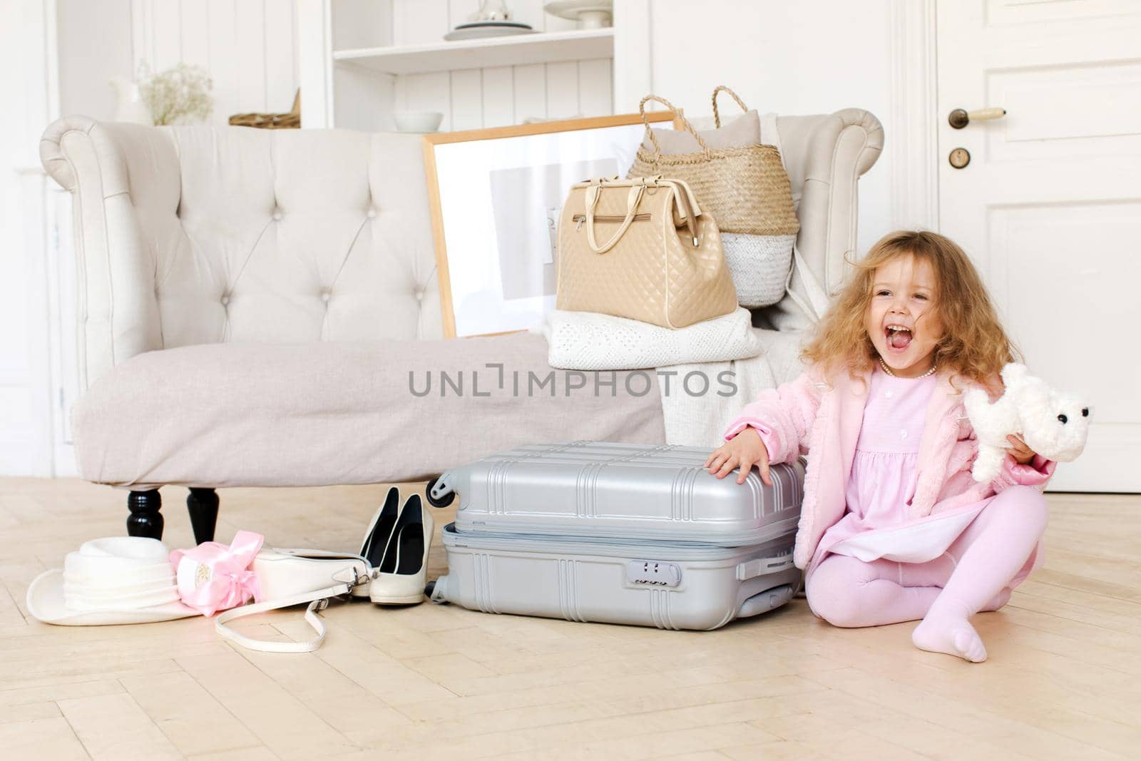 Happy little girl playing with a retro suitcase by Demkat