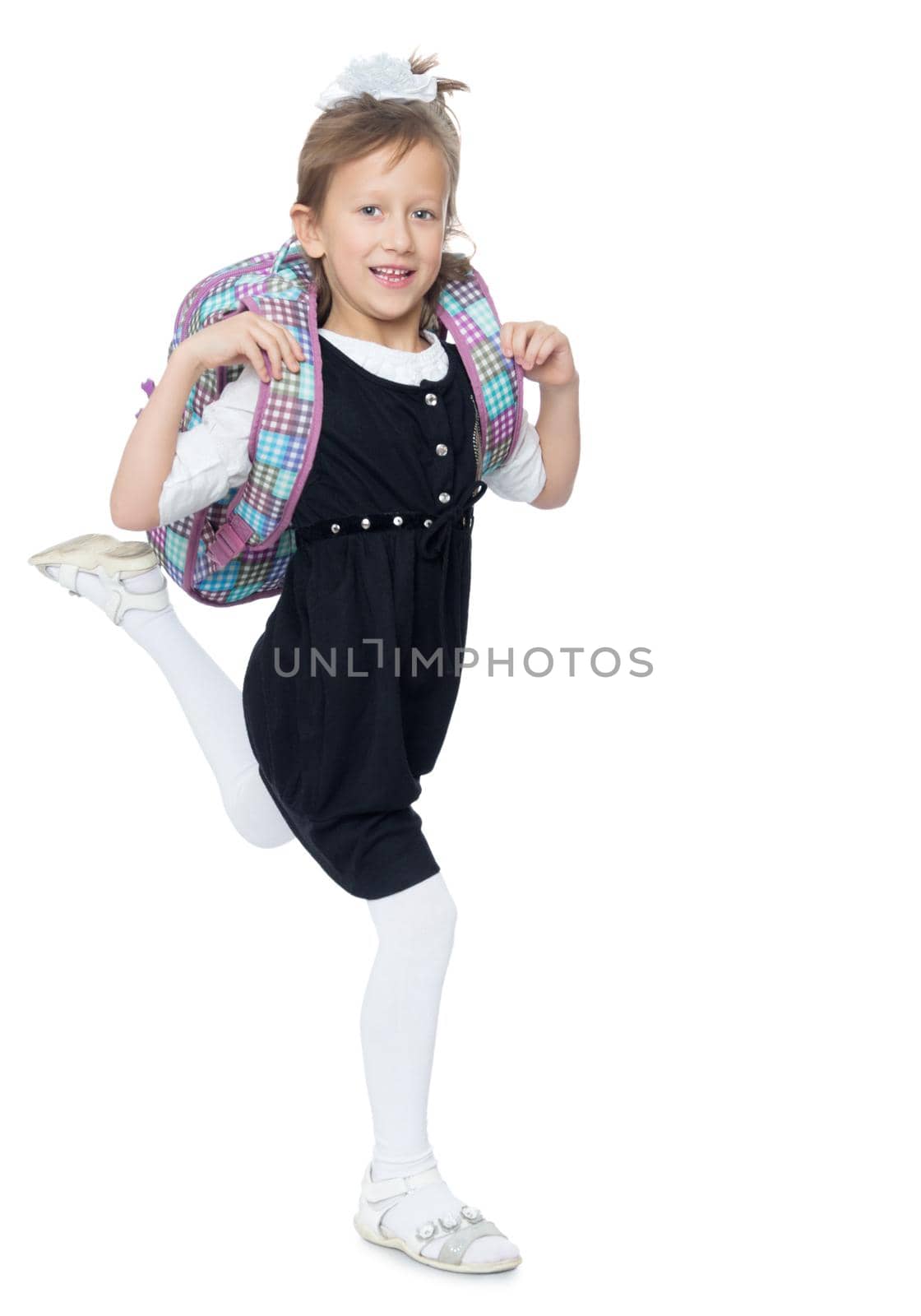 Happy little girl hurries to school . It carries over the shoulder school backpack - Isolated on white background