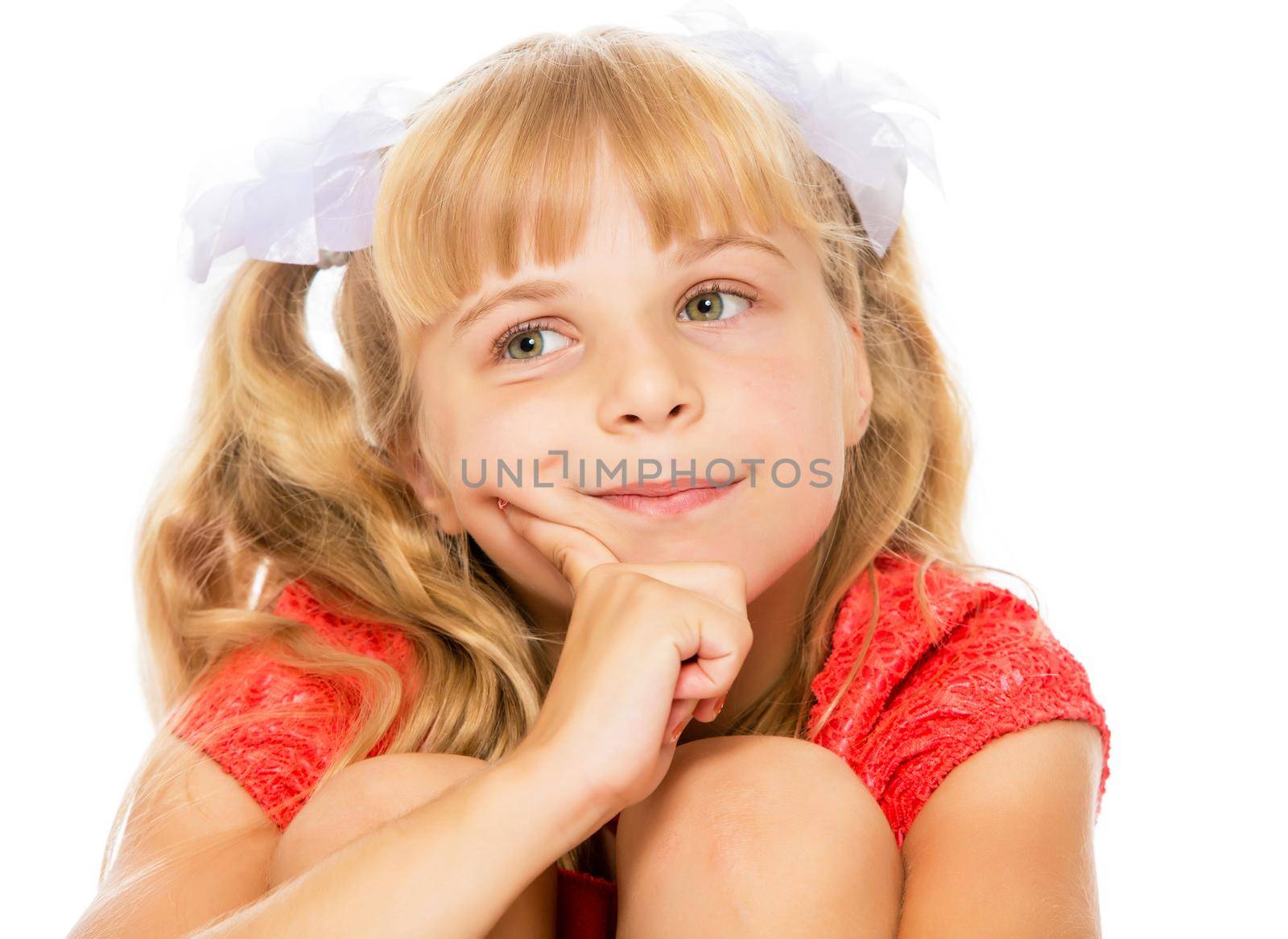 Closeup of a beautiful little girl with long, blonde ponytails on her head in a bright orange dress . The girl about something thinks-Isolated on white background