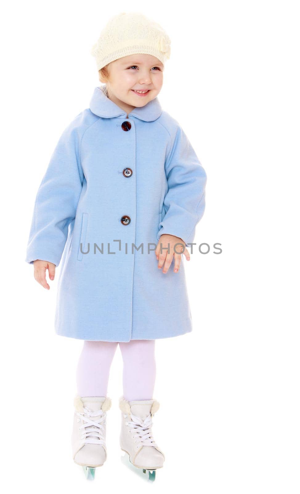 Cute little girl figure skater in a blue coat and a white cap is standing on skates with two blades-Isolated on white background
